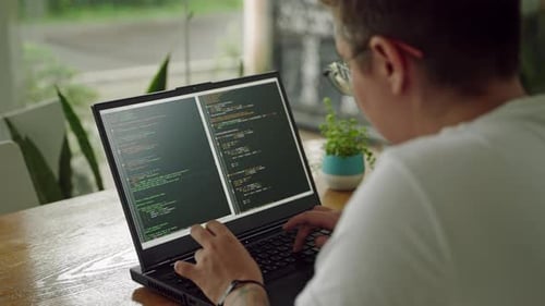 Transgender Developer Programs on Laptop at Plantfilled Workspace Codes Reviews Scripts in Casual