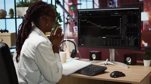 Woman at Desk Celebrating Investing Success