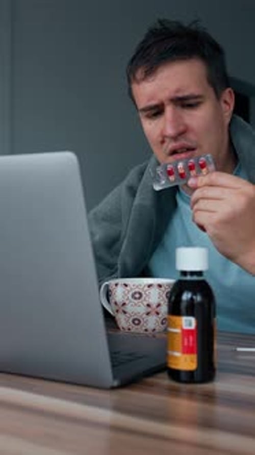 Vertical of Sick Man Checks Instruction for Pills in Internet Via Laptop