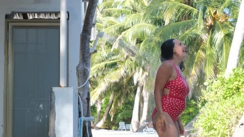 Young Woman Taking Shower on a Tropical Beach