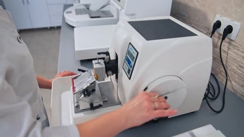 Technician Cutting Tissue Sample with a Microtome Machine