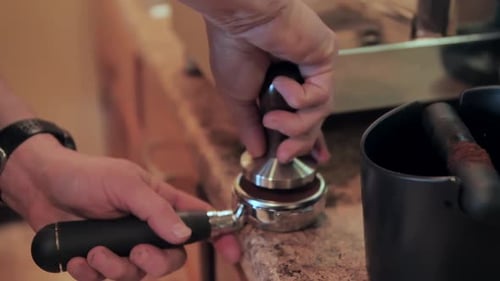 Using a portafilter to make cup of espresso coffee, slow motion close up
