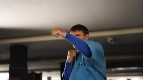 Martial Arts Man in Kimonos Practices Kicks and Punches Male Fighter Wearing Kimono Training in Gym