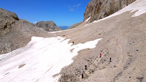 A group of people are hiking up a snowy mountain