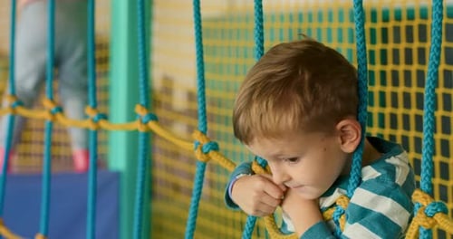 Child Playing in Indoor Playground with Rope Netting