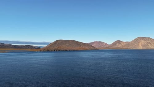 Navega por la bahía de Rumilet hacia picos distantes y aguas azules por la noche en Chukotka