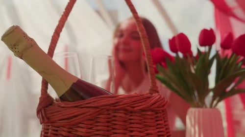 Woman Smiling with Champagne Picnic Basket and Flowers
