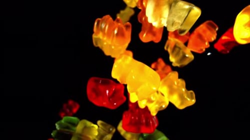 Colorful Gummy Bear Candies Floating on Black Background