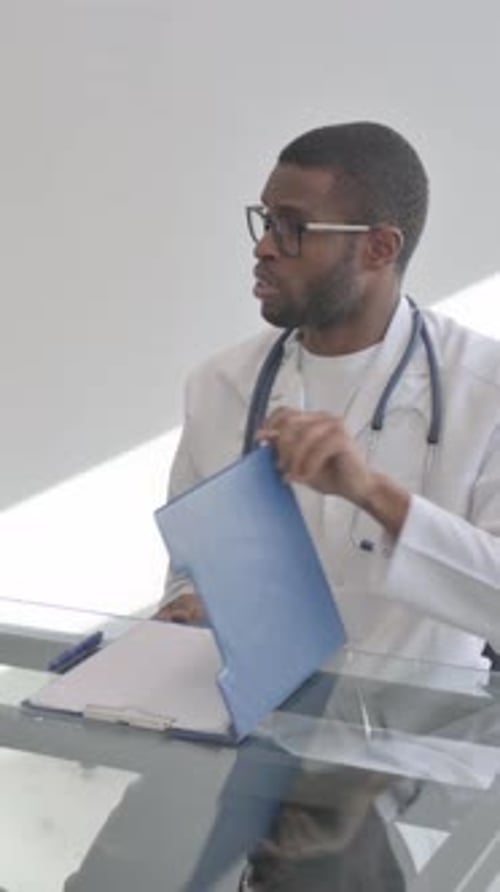 Professional Doctor Writing on Chart in Office Setting