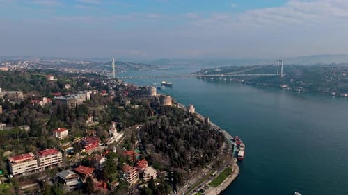 Wide Angle Drone View of a Cargo Ship Sailing Through the Bosphorus in Istanbul