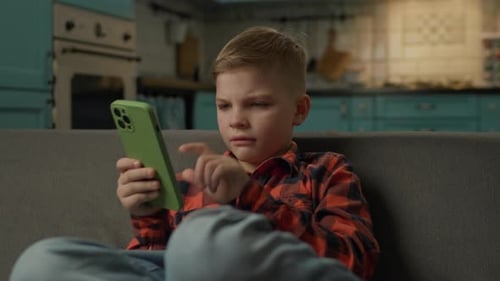 Boy Using Smartphone While Sitting on Couch