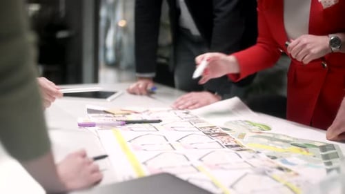 Architects Collaborating on Plans in Modern Office