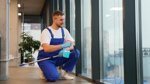 Concierge professionnel lavant les grandes fenêtres de bureau