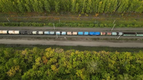Güterzugwagen, die im Herbst durch den Wald fahren, Luftbild, Frachttransportkonzept