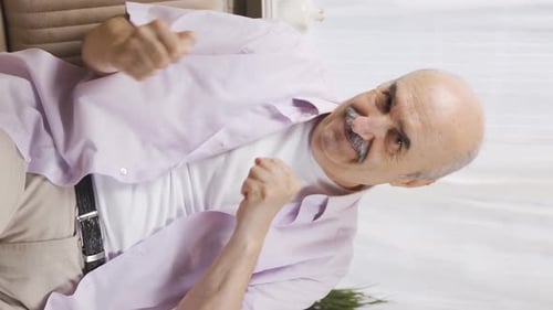 Vertical video of Happy old man dancing to the camera.
