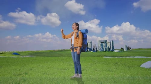 Full Body Side View Of Asian Female Hiker Celebrating in Stonehenge