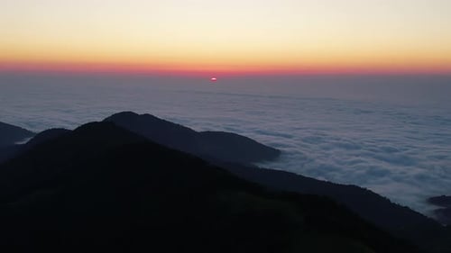 Sunset goes into the clouds. Evening clouds and mountains background 4K.