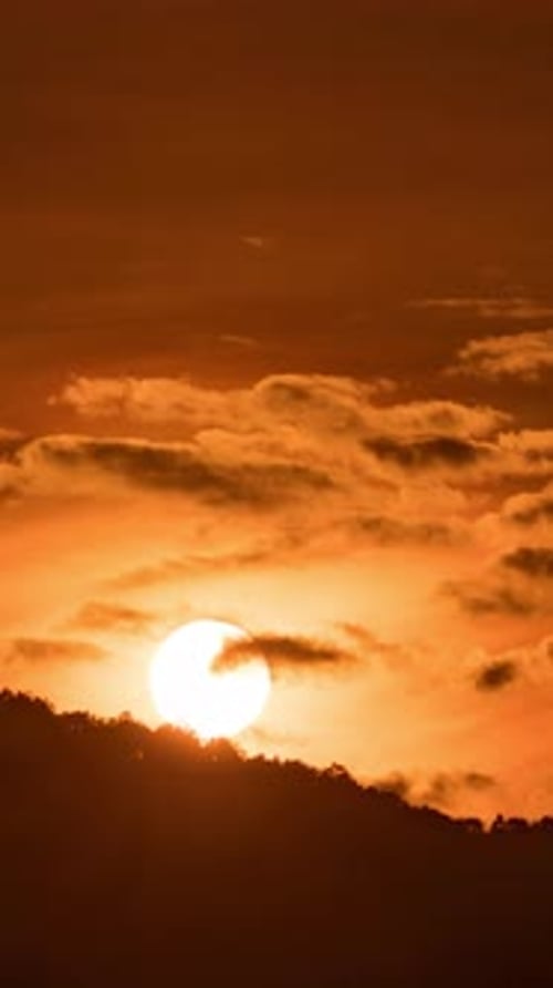 Zeitraffer bei Sonnenaufgang in den Bergen mit fließendem Nebel und Morgenlicht, das auf die Bergrücken trifft.