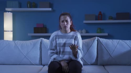 Distressed Woman Using Hand Gestures On Couch