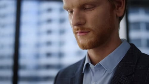 Focused businessman browsing internet on tablet computer in modern office