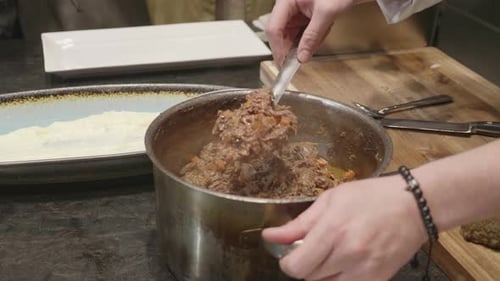 Chef Adds Food Into a Long Dish