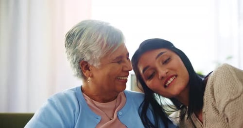 Smiling Women Embracing Indoors in Soft Light