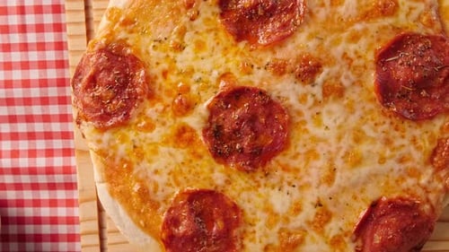 Overhead Close-up of Delicious Pepperoni Pizza on Wooden Board