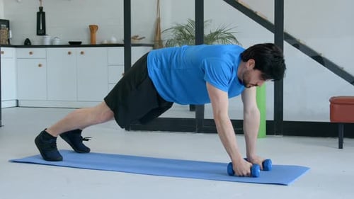 Active Sporty Fitness Man Performing Dumbbell Renegade Row Exercise