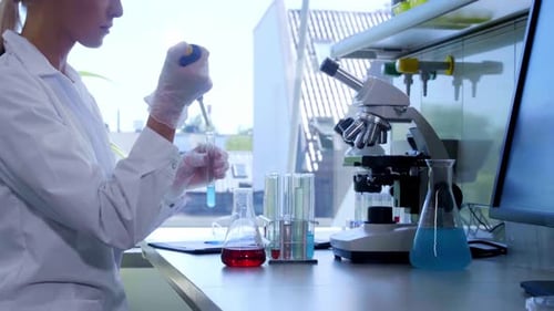Scientist Using Pipette in Laboratory for Scientific Research