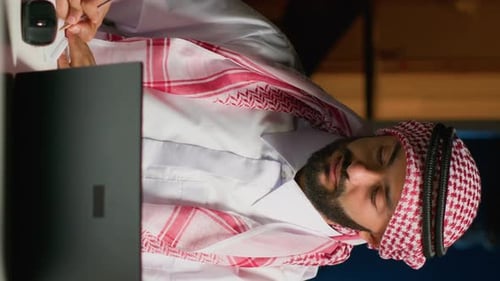 Man Wearing Headscarf Working at Computer