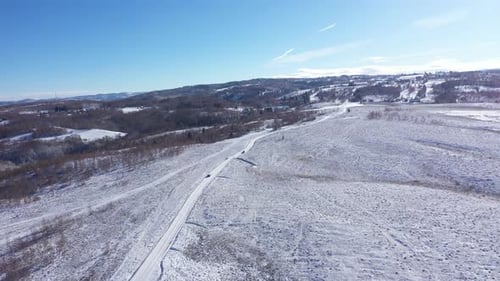 Aerial View of Car Driving on a Winter Road. Winter Countryside Landscape