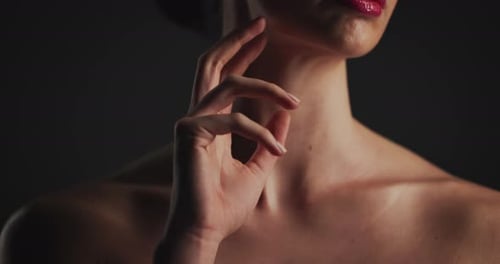 Hand, glow and woman in studio for skincare, dermatology and self care isolated on black background