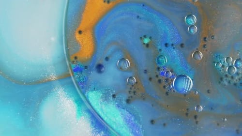 Vibrant ink swirling in water with a mesmerizing mix of blue and orange tones, shot