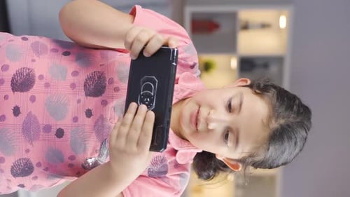 Smiling Girl Using Smartphone Indoors