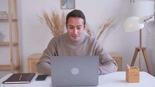 Man Works on Laptop at Home Office Desk