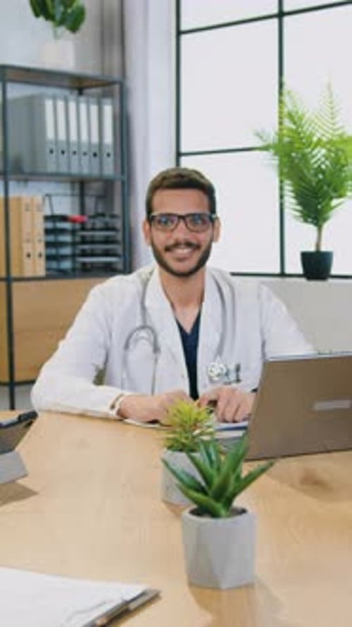 Close Up of Handsome Positive Highskilled Professional Bearded Male Medical Worker in White Coat in