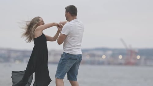 A Cute Married Couple Dancing on the Pier in Cloudy Weather