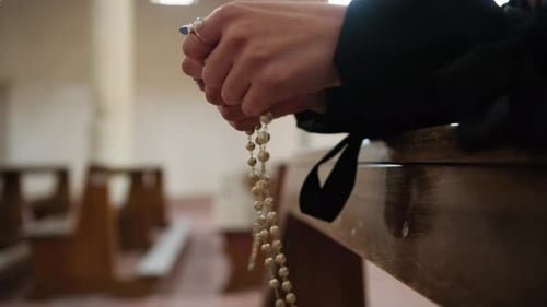 Woman Makes The Rosary Sitting Praying In Church For Peace