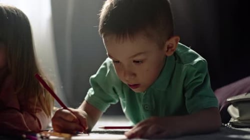 Children Drawing with Pencils on Floor at Home