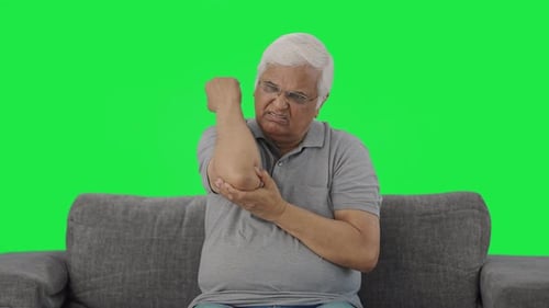 Sick Indian old man suffering from arthritis Green screen
