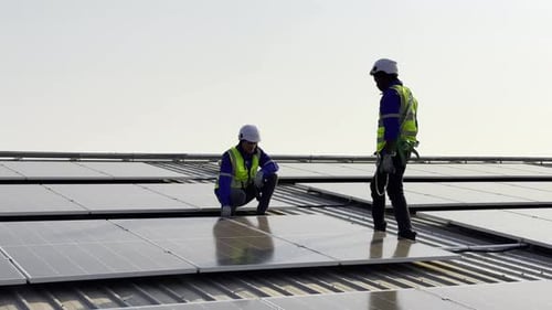 Technician installing solar cell. Installation and maintenance of solar cells on rooftop.