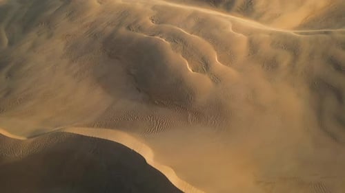 Drone Pullback Over Sculpted Sand Dunes