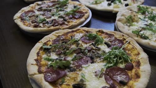 Lots of Pizzas on the Table in a Pizzeria