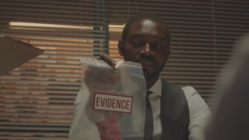 Man Holds Evidence Bag in Office Setting
