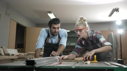 Carpenters are working together at workshop.
