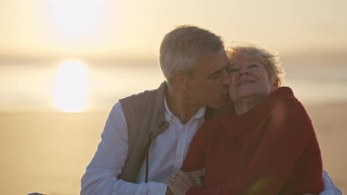 Senior Couple Embracing on Beach at Sunset