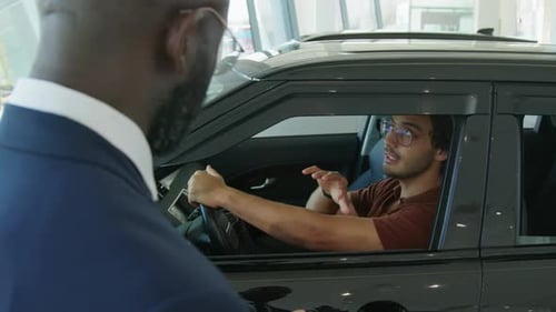 Young Adult Talking to Car Salesperson in Dealership