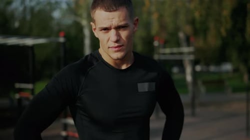Focused Young Man Takes a Break During Outdoor Workout