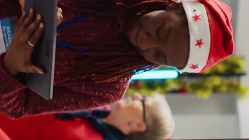 Woman Wearing Santa Hat Using Tablet in Office