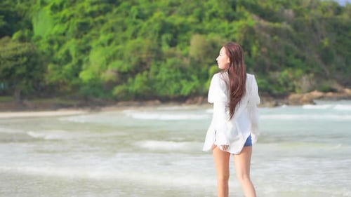 Woman Walking Barefoot on a Tropical Beach
